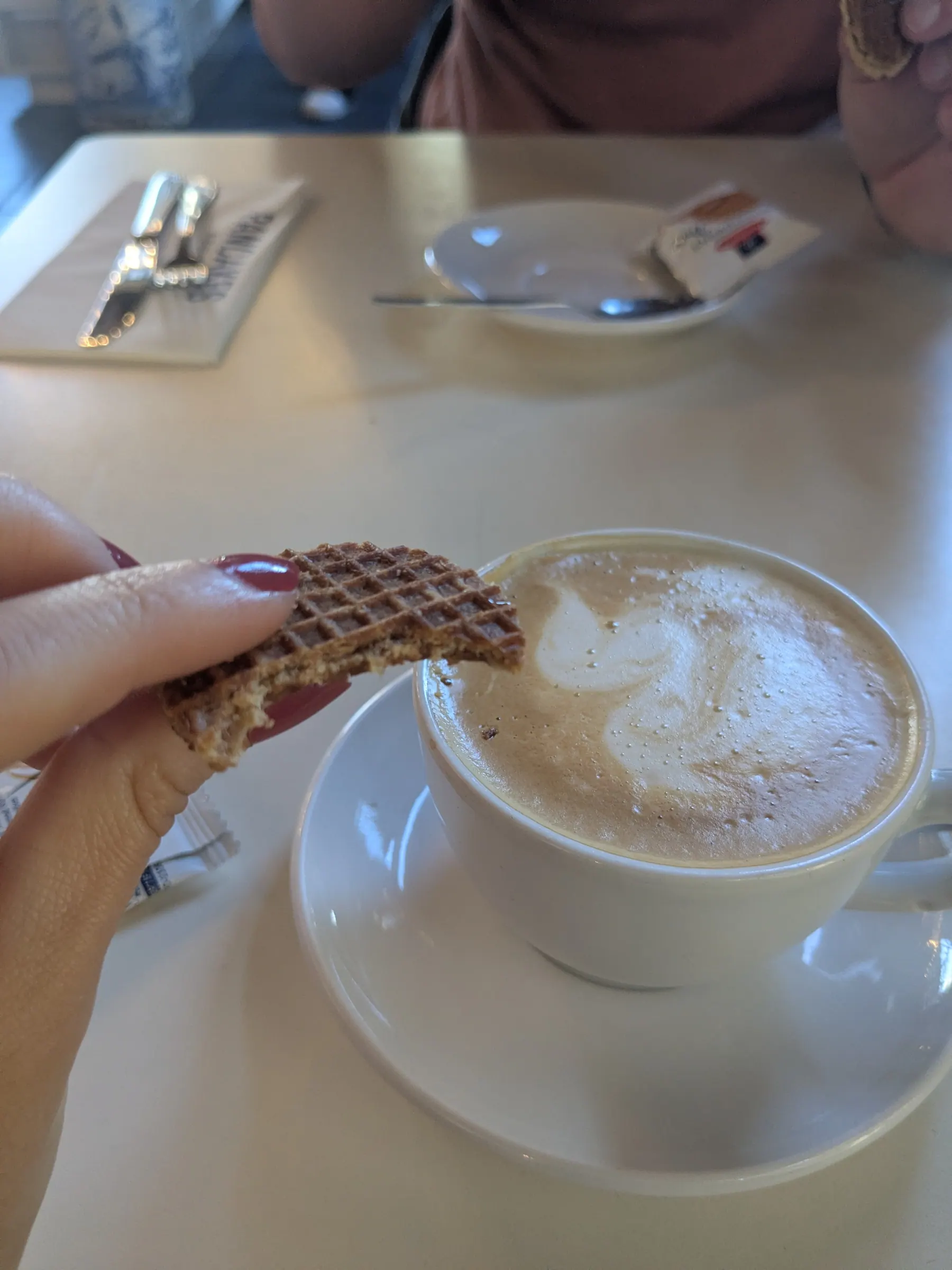 A cappuccino and stroopwafel at a table in Amsterdam