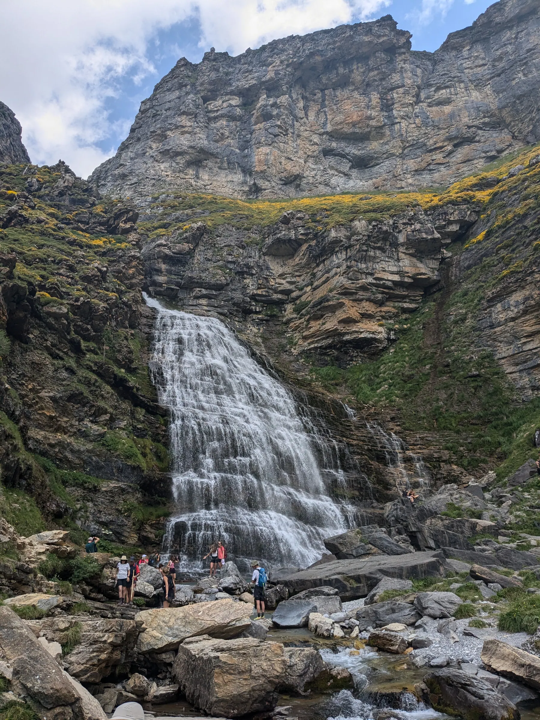 The Cola de Caballo waterfall surrounded by hikers and rocky cliffs