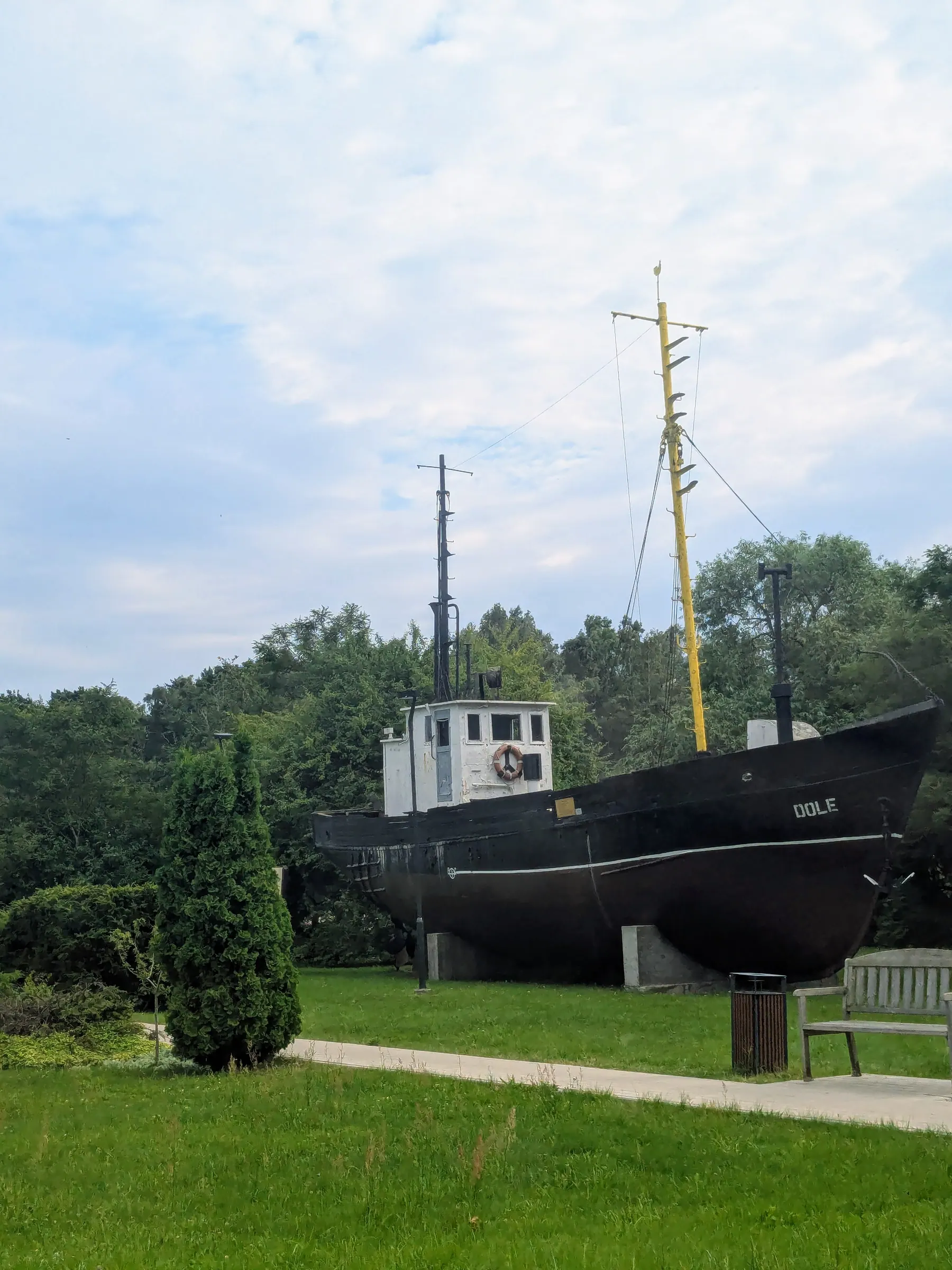 A historic fishing boat displayed beside Pāvilosta Local History Museum