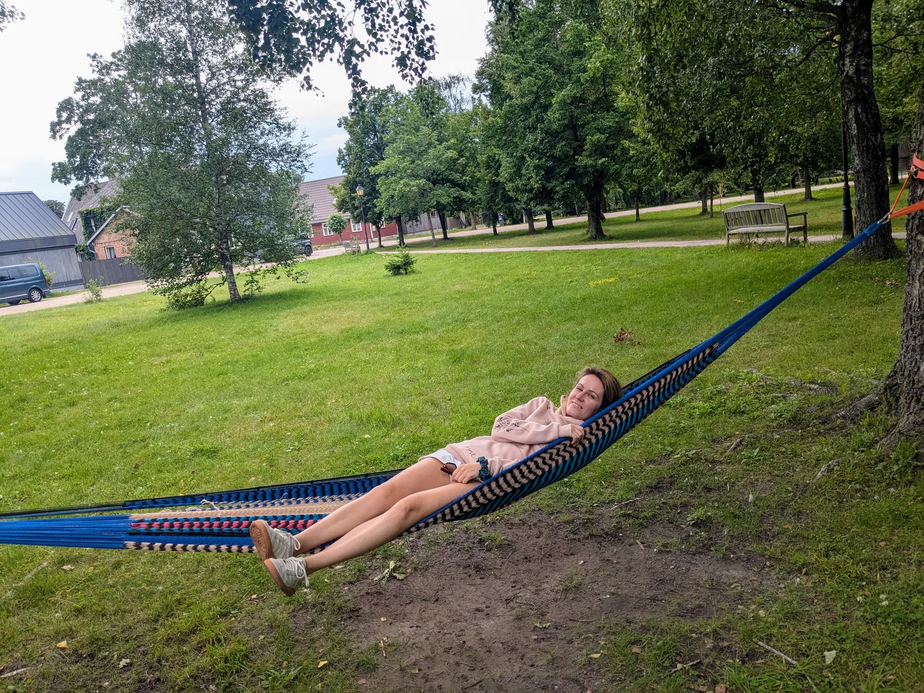 A visitor resting in a hammock in the green garden at PAiR in Pāvilosta