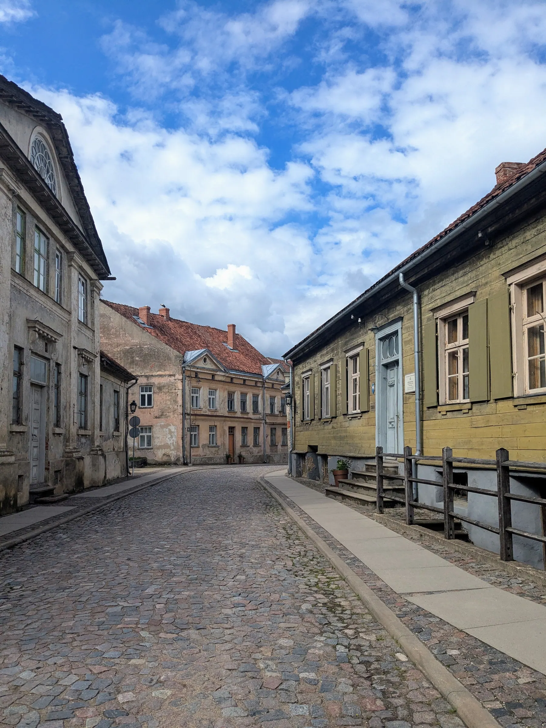 Historic buildings on a cobbled street in Kuldīga, with Steffenhagen's house in the distance