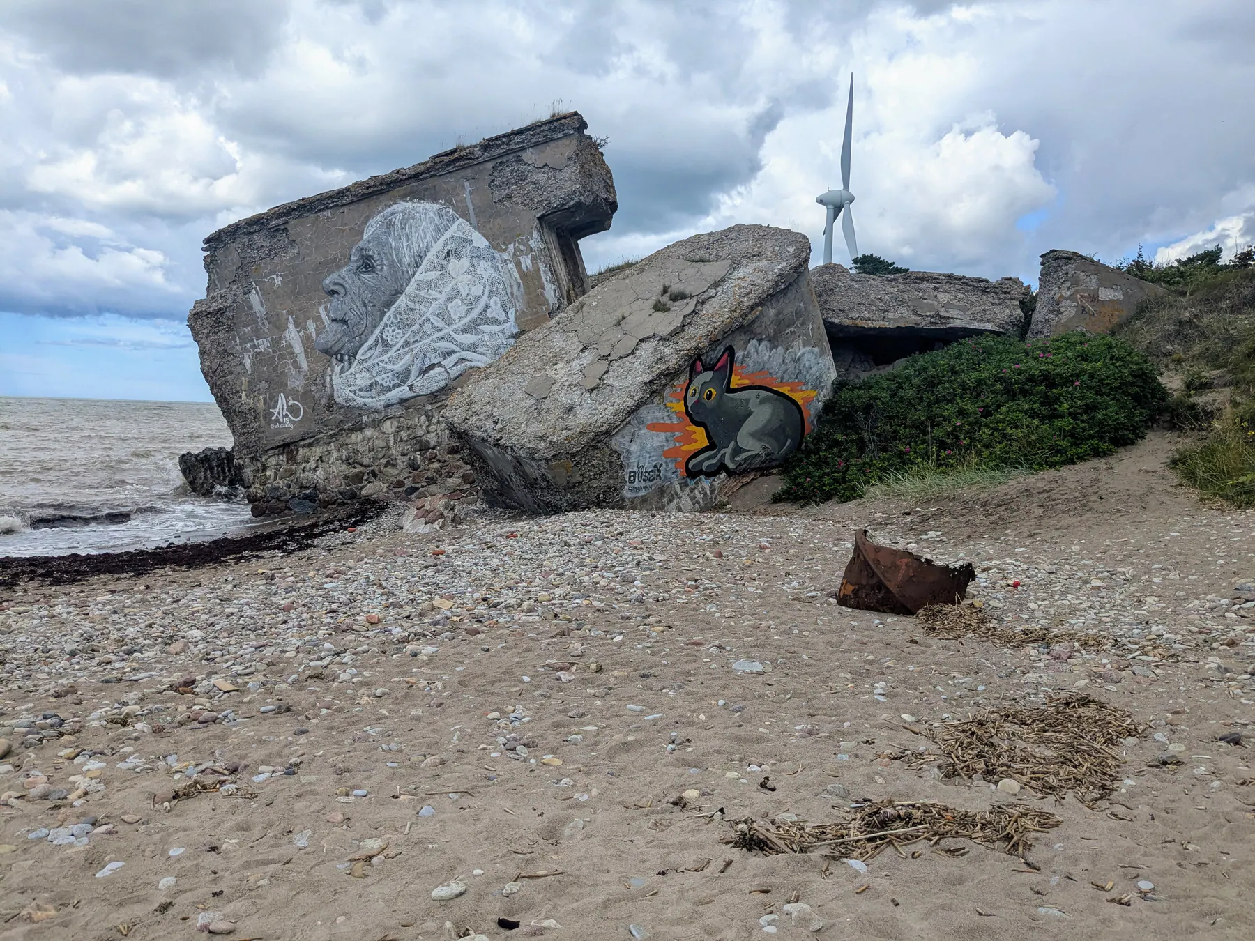 A fallen Northern Fort slab covered with a large mural beside the beach