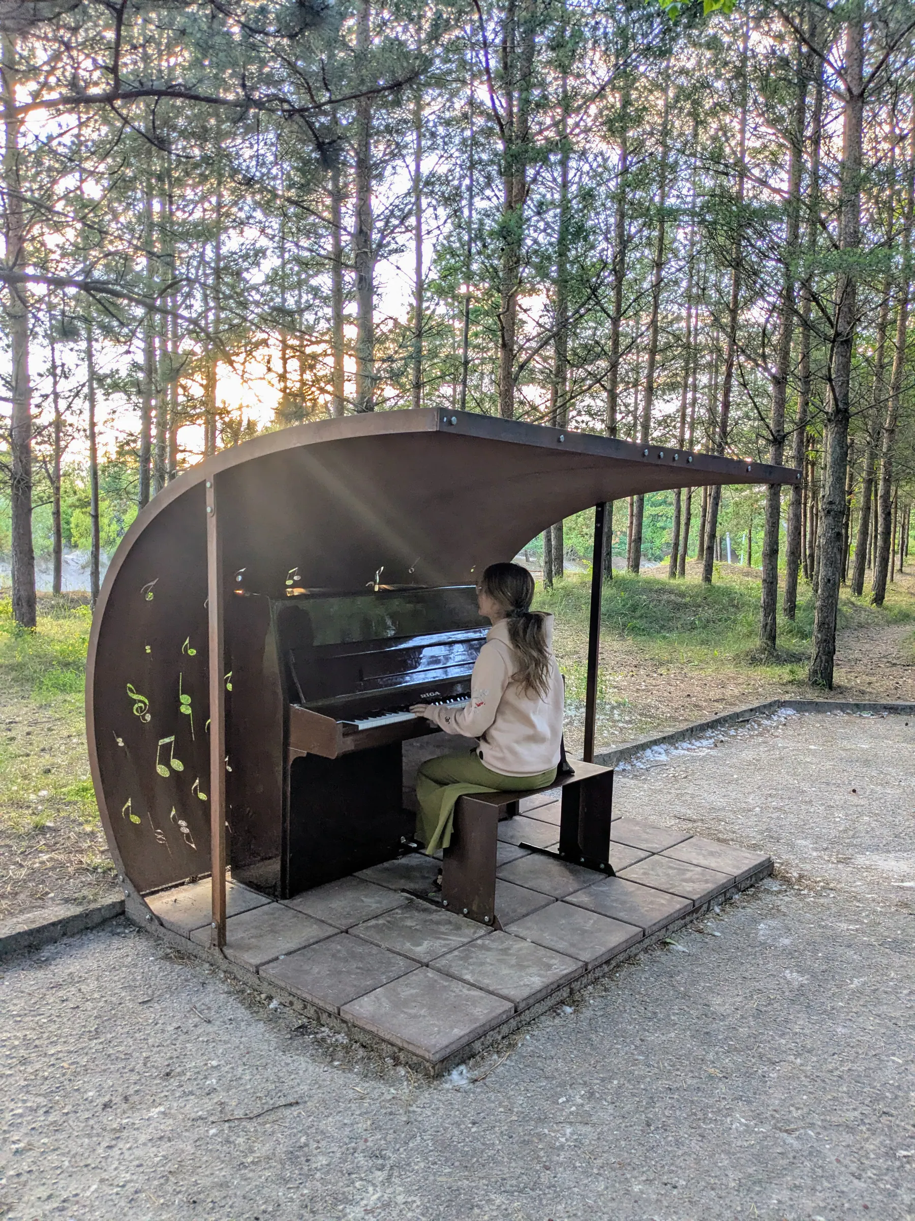 A playable piano inside a curved shelter near Liepāja beach