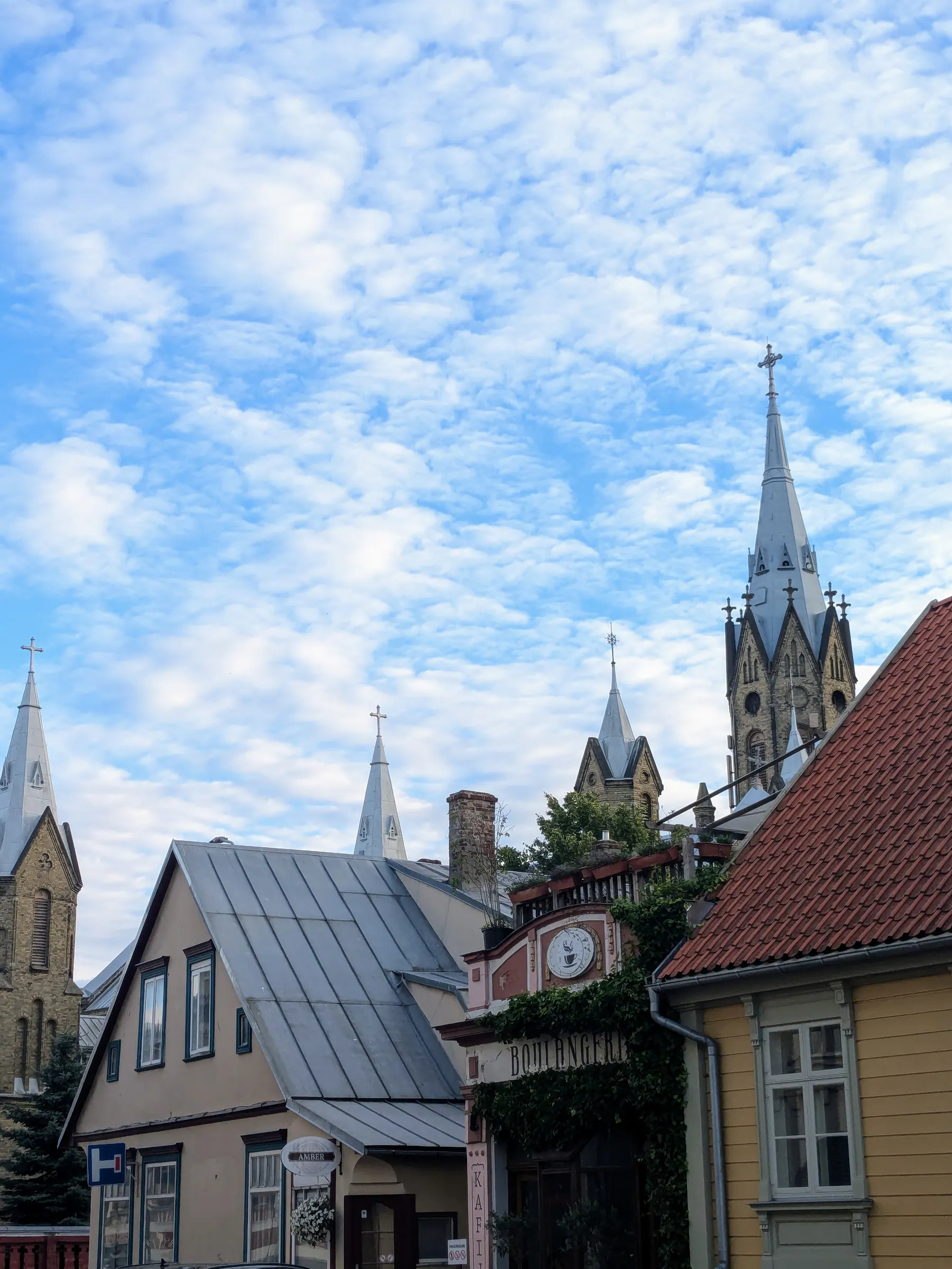 Church spires rising above wooden and brick houses in Liepāja