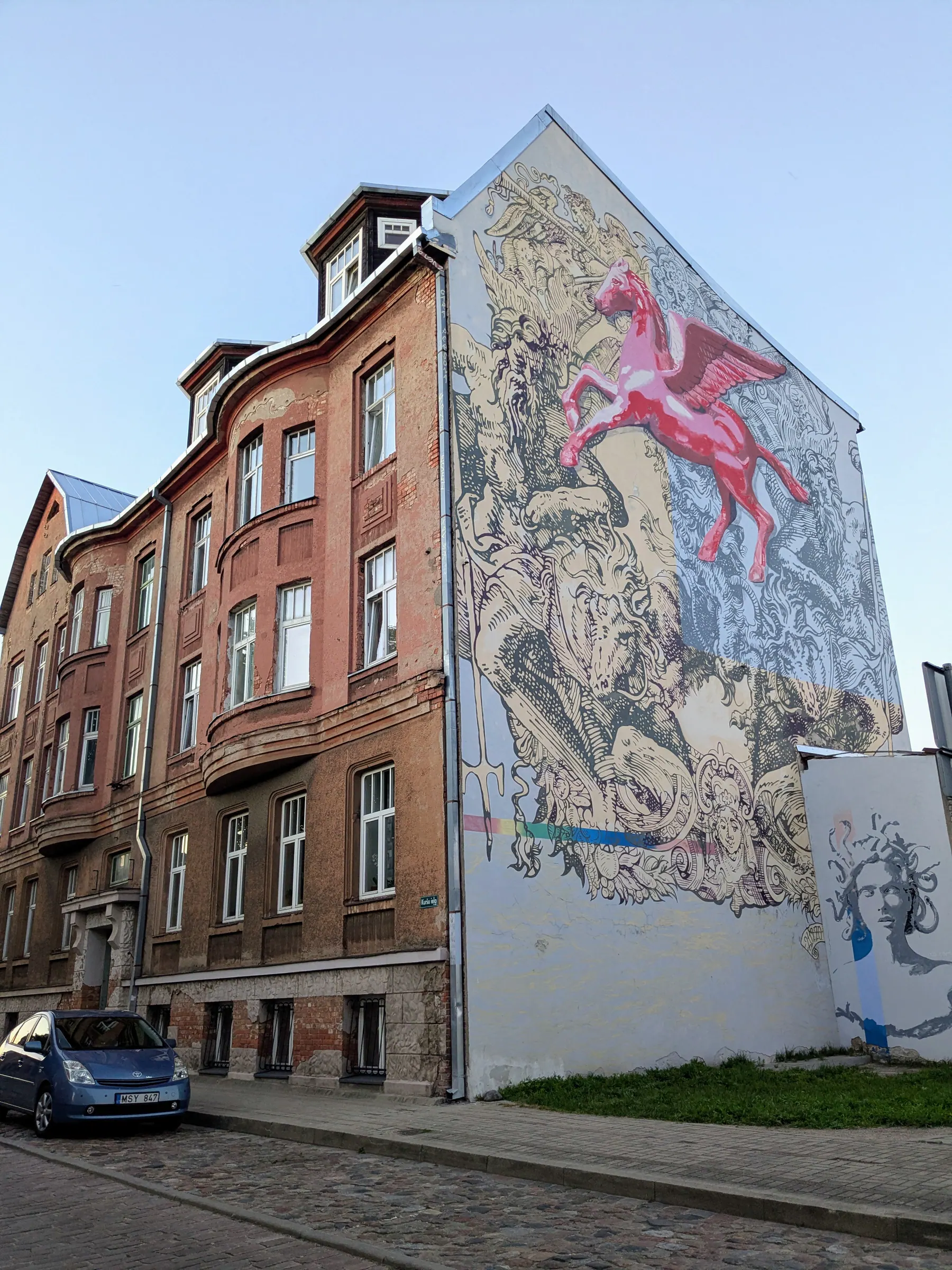 A large mural of a woman and bicycle on a Liepāja apartment building