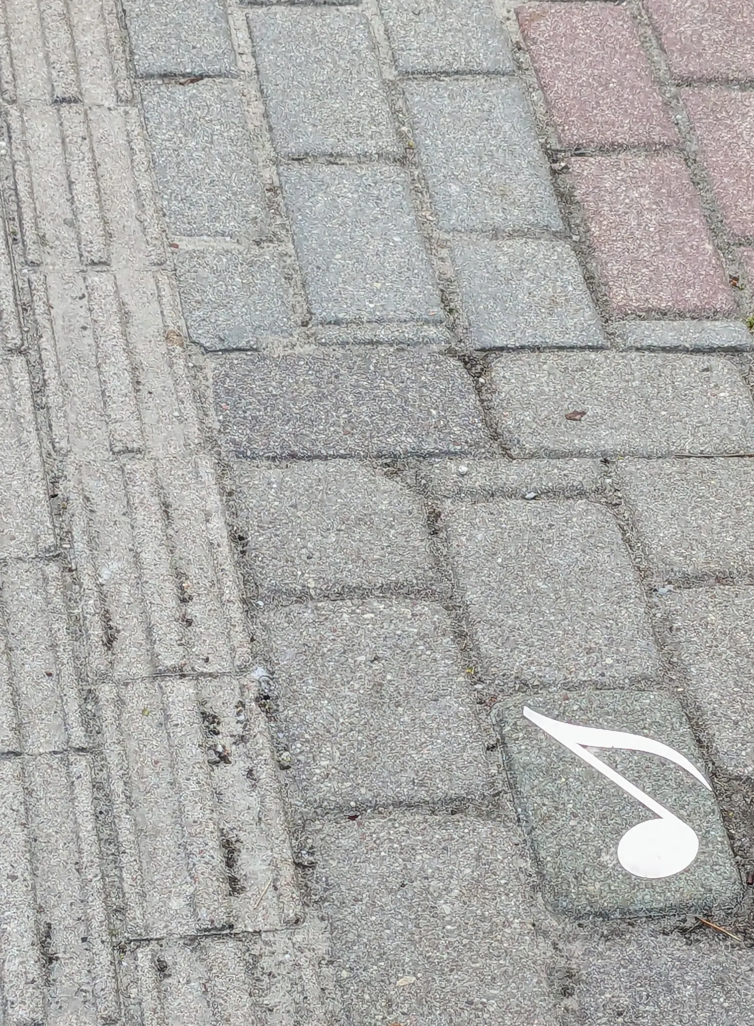 A musical note marker set into the pavement in Liepāja