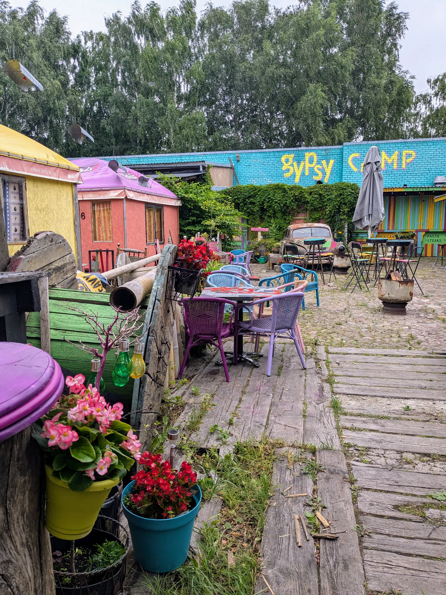 A colourful courtyard filled with flowers and reused objects at the Gipsy Camp