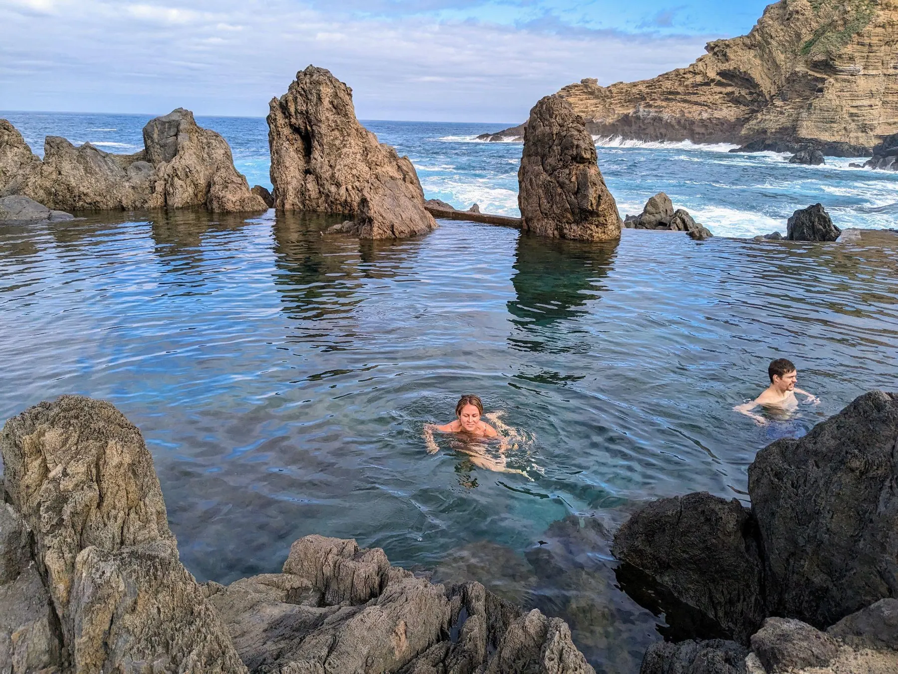 People swimming in the volcanic natural pools of Porto Moniz