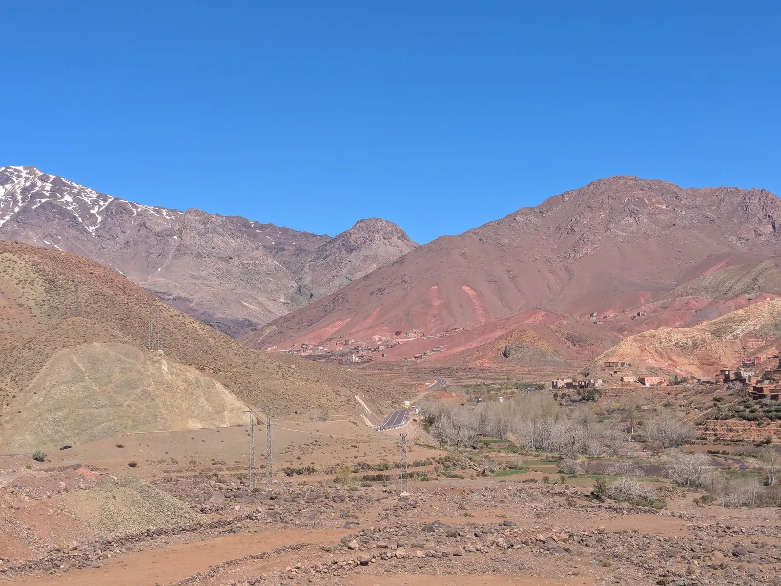 Road through the Atlas Mountains in Morocco with dry valleys and snow-touched peaks
