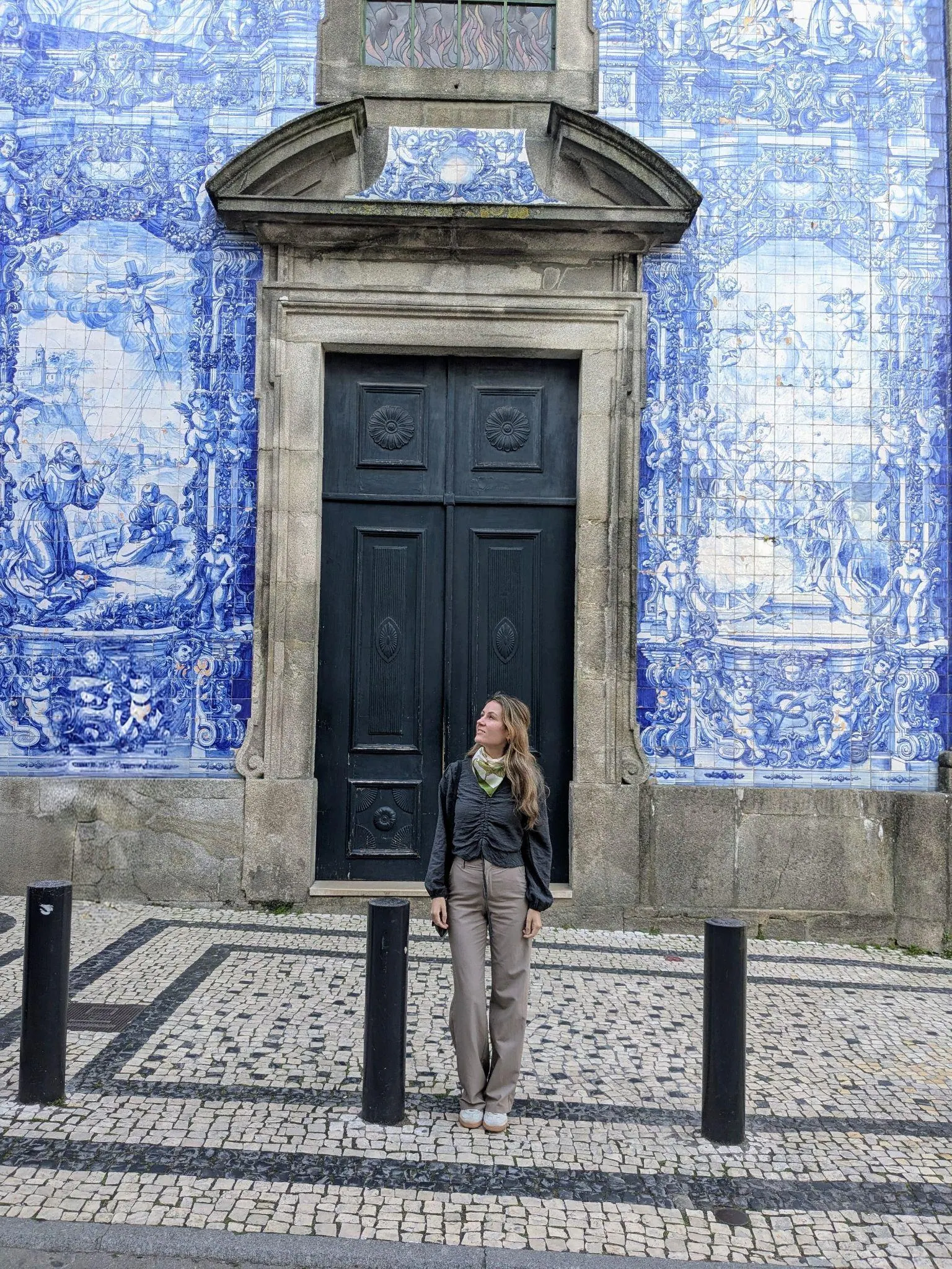 A traveler standing beside the tiled Chapel of Souls in Porto