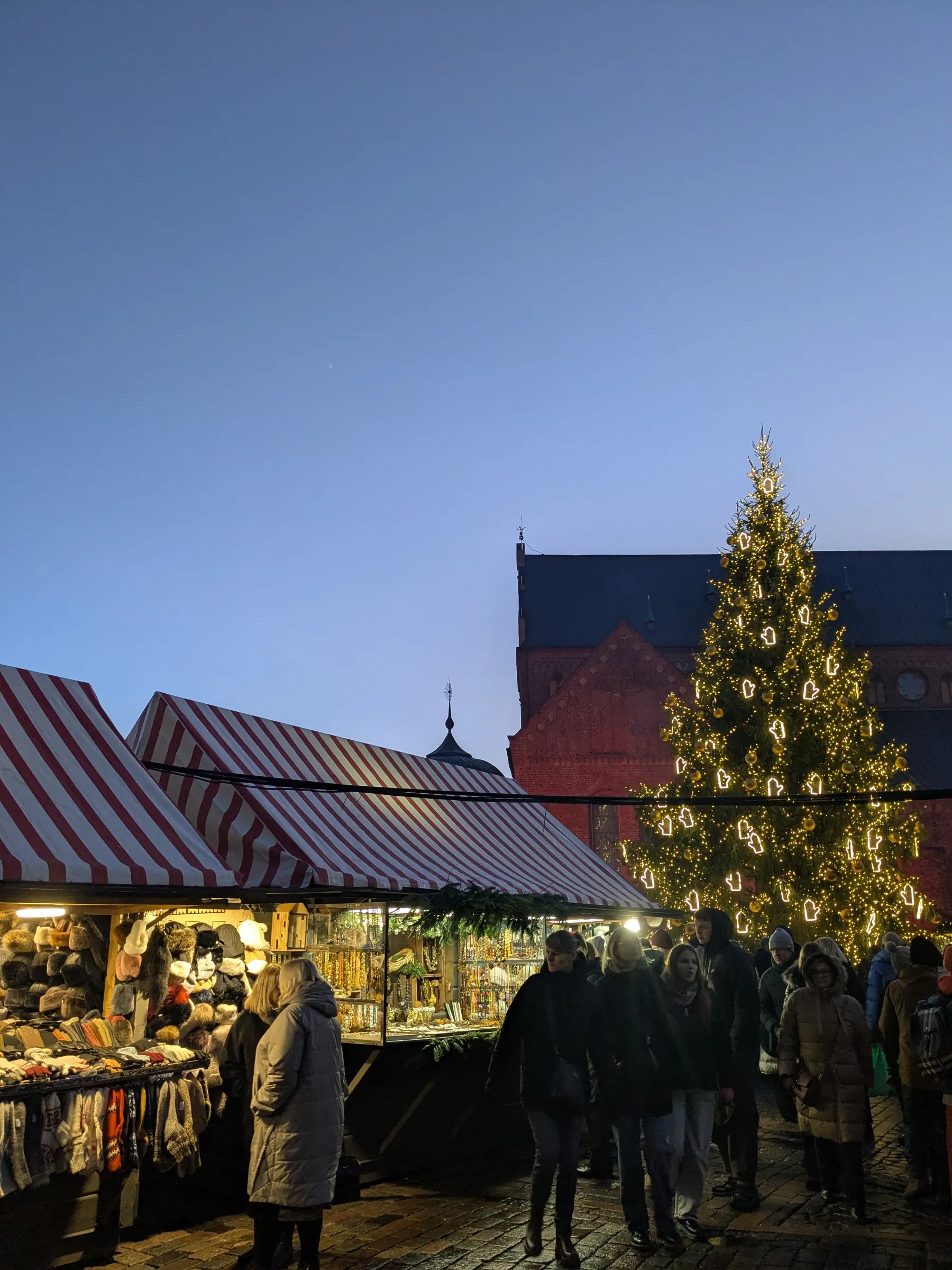 Wooden market stall displaying traditional patterned Latvian wool mittens and knit winter hats at Dome Square
