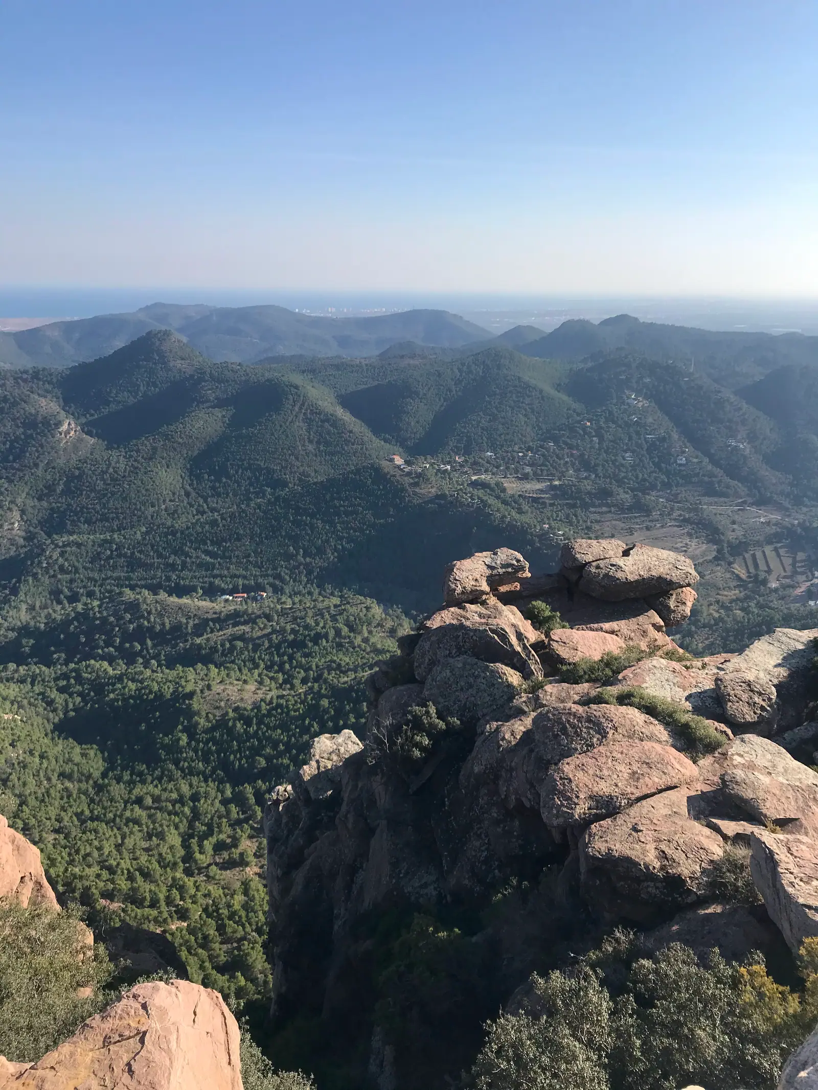 Red sandstone formations and forested ridges below Mirador del Garbí