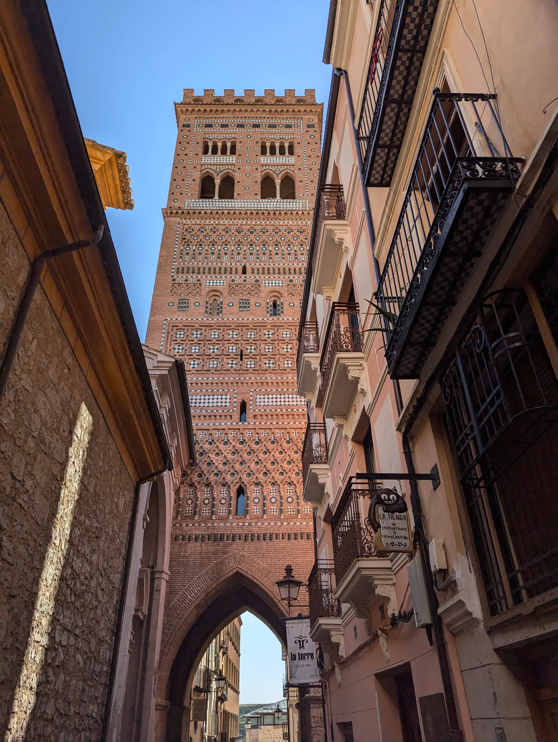 The Mudéjar Tower of El Salvador framed by a street in Teruel