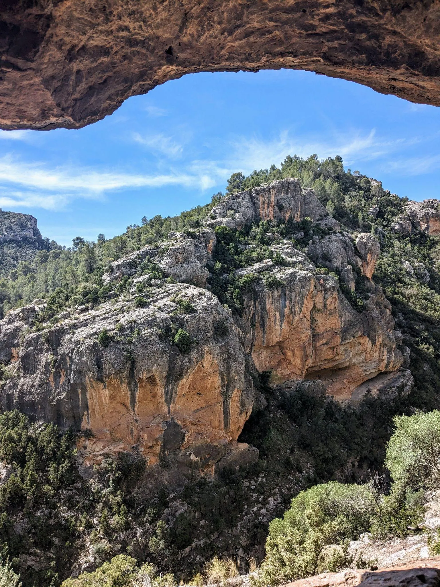 A natural rock window carved into the high cliff wall of the Roman aqueduct overlooking the gorge