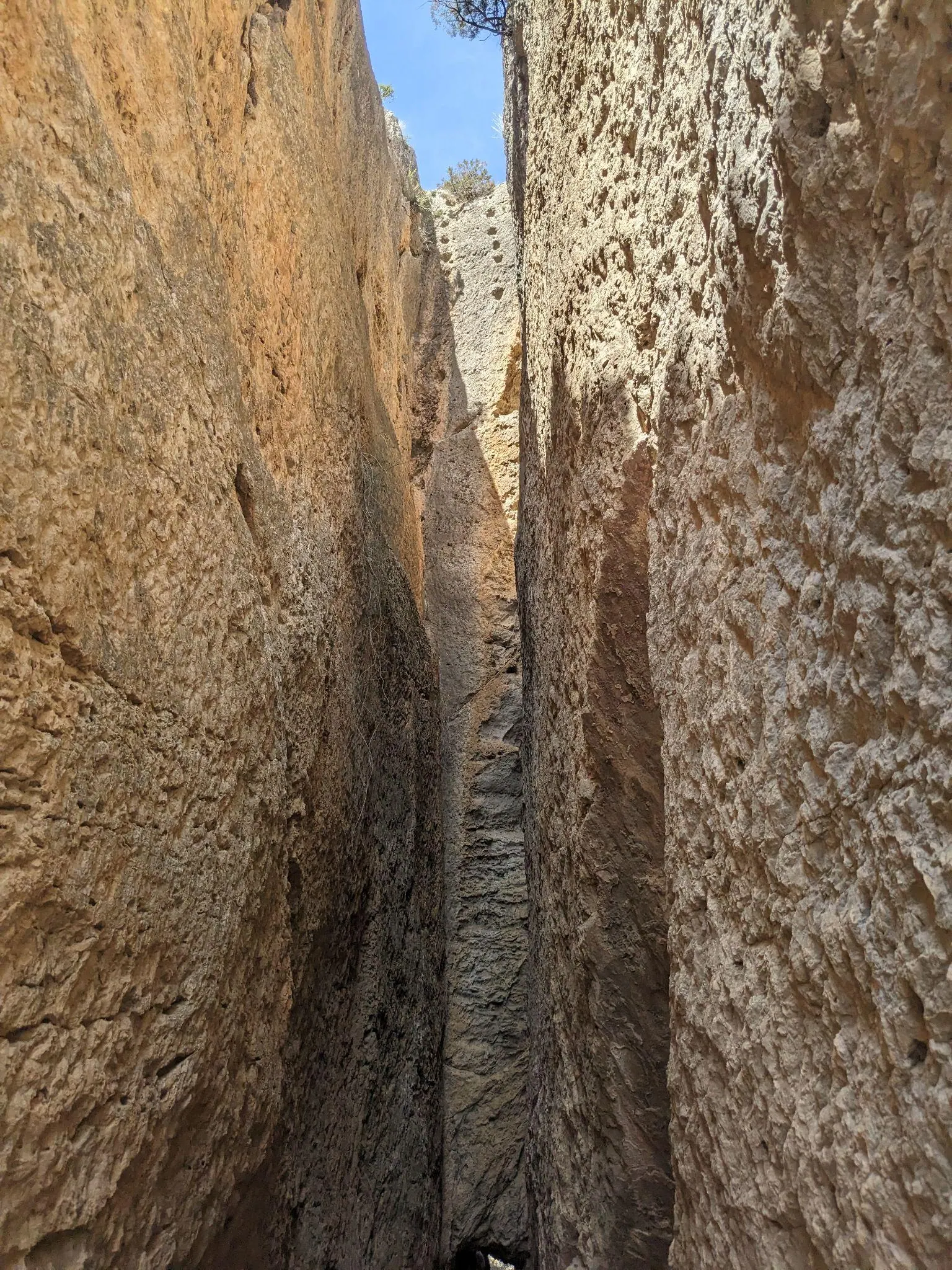 A narrow hiking trail slicing between two towering sheer rock walls cut by the Romans