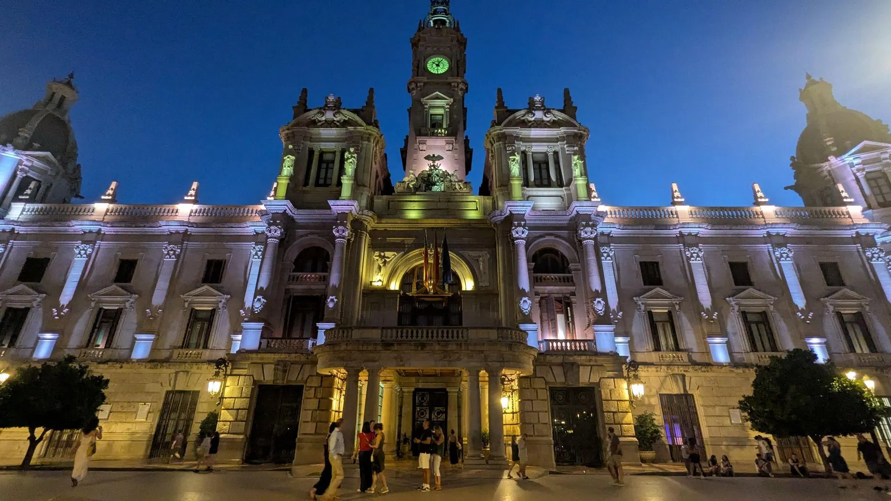 Façade and clock tower of Valencia City Hall illuminated at dusk facing Plaza del Ayuntamiento