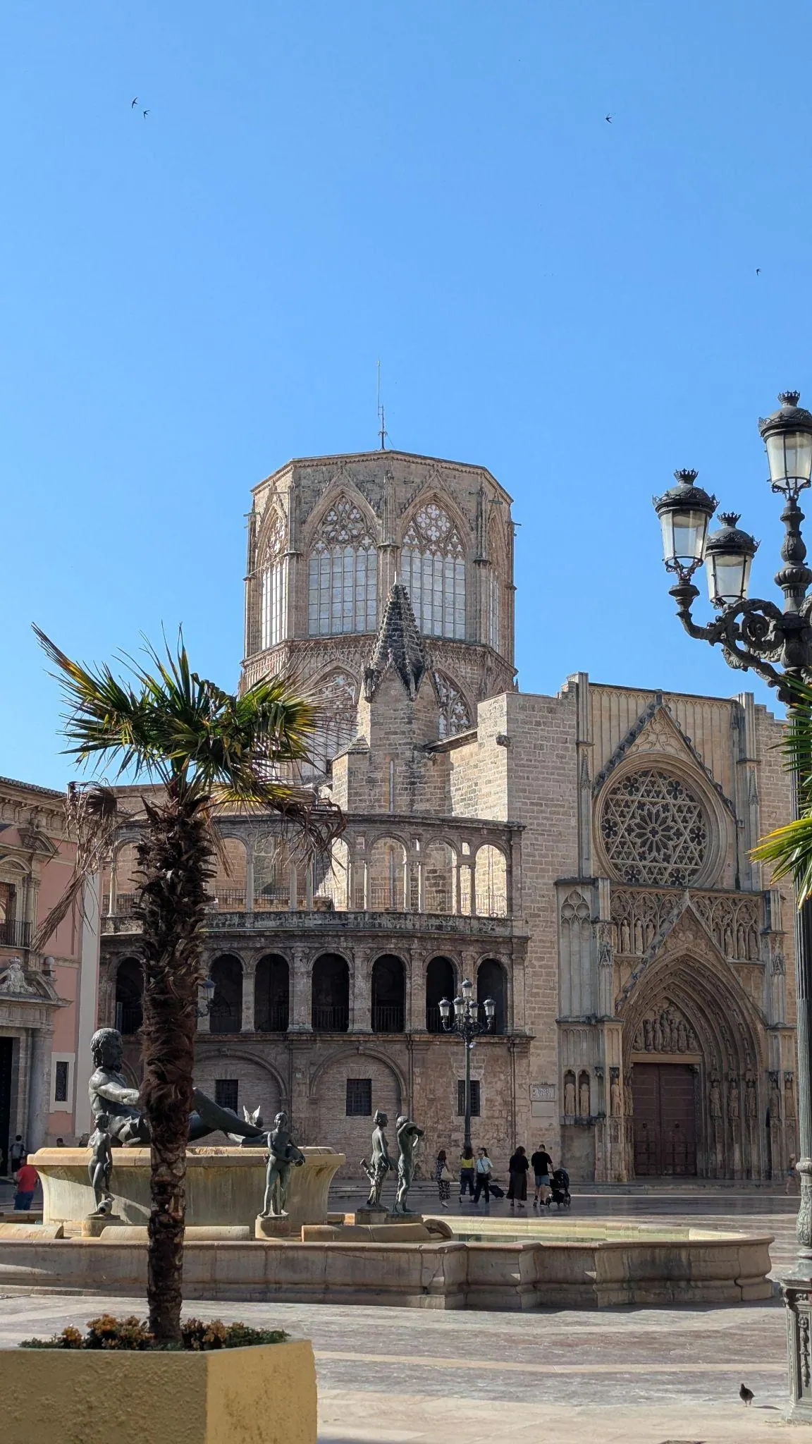 Open flagstone square of Plaza de la Virgen with historic Cathedral facade in evening light