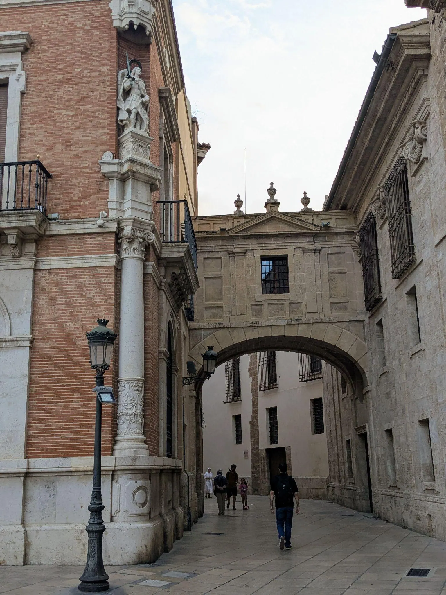 Gothic stone arch bridge of Arco de la Barchilla spanning the narrow alleyway behind Valencia Cathedral