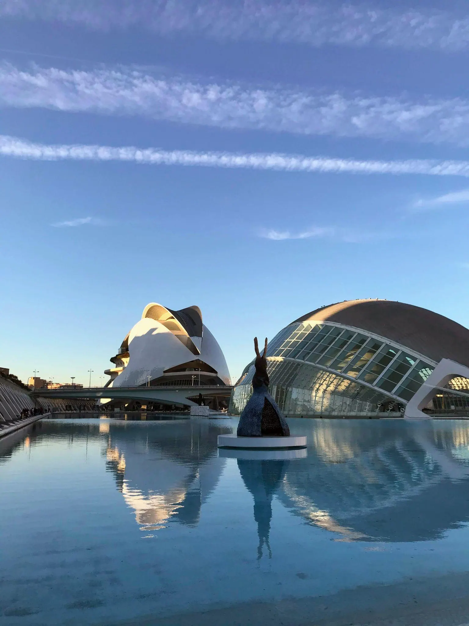 Futuristic white architecture and sweeping footbridges reflected in turquoise pools at Ciudad de las Artes y las Ciencias