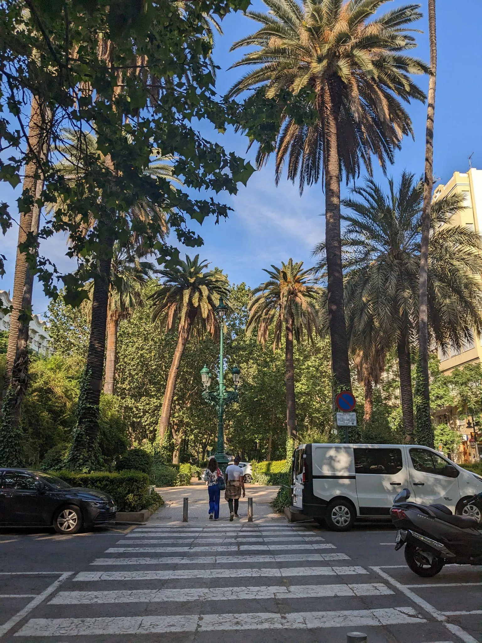 Palm-lined boulevard and crosswalk along Gran Vía Marqués del Turia heading towards Ruzafa